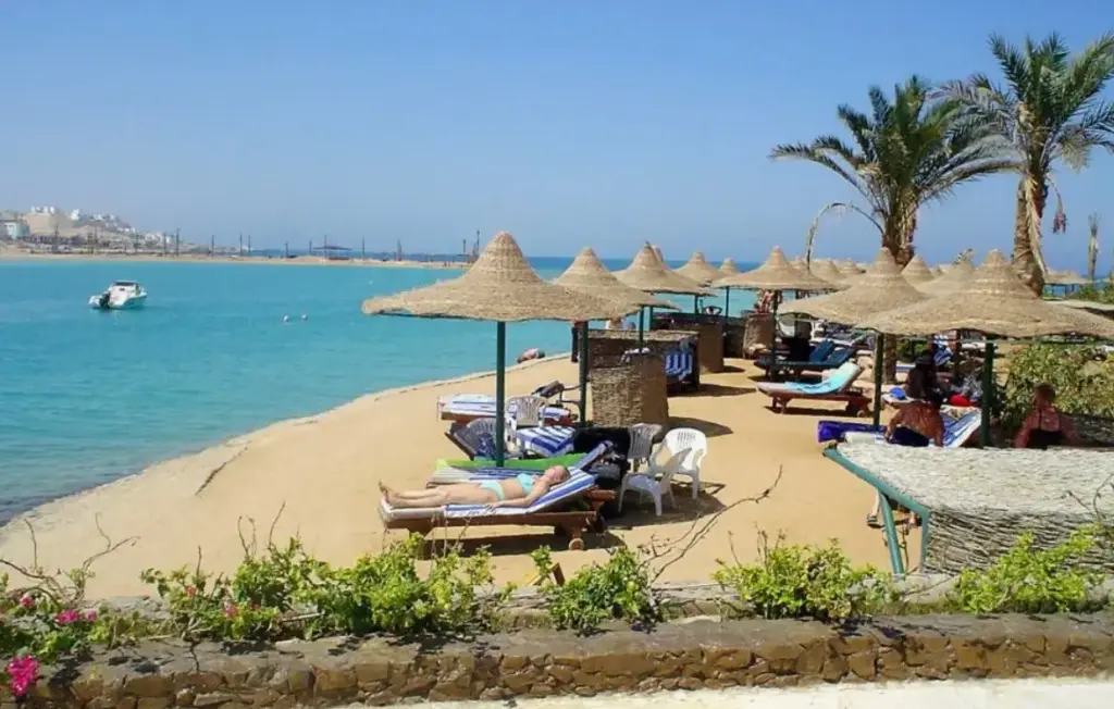 Пляж с зонтиками и спокойным морем показывает атмосферу отдыха и отражает погоду по месяцам в Египте, включая март.