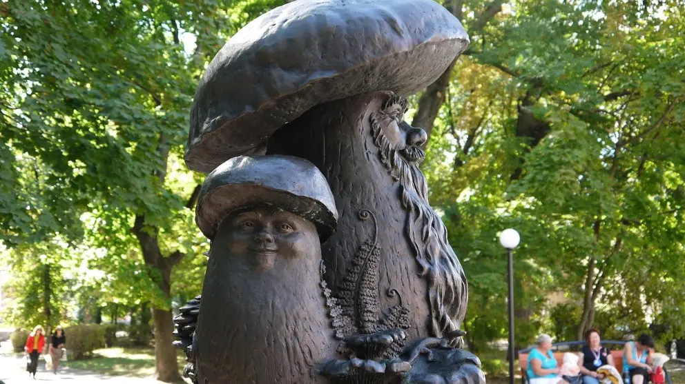 Что делать, если собрались на экскурсию, а погода испортилась: бронзовая скульптура грибов в городском парке на прогулочной аллее