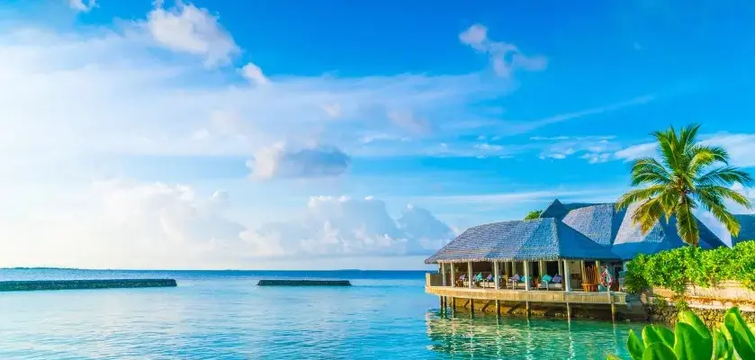 Что входит в страховку тура — домики на воде у бирюзового моря и голубого неба.