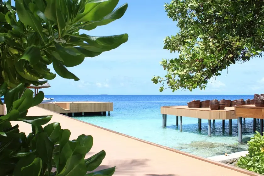 Что входит в страховку тура — пирс и терраса над прозрачной водой у тропического берега.