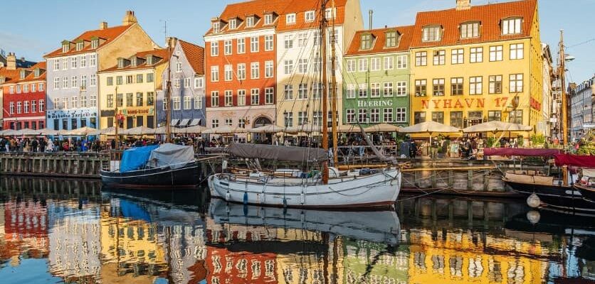 Как отменить тур и вернуть за него деньги — набережная европейского города с лодками и яркими домами