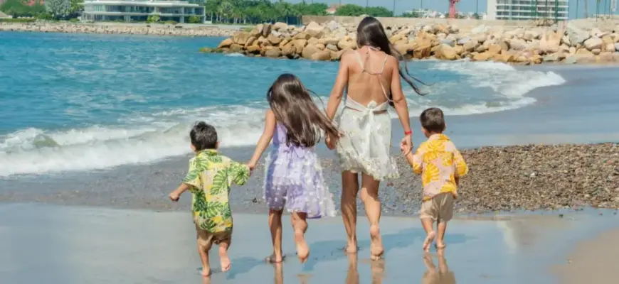 Как считать цены на туры с детьми — семья с детьми на пляже у моря во время отпуска.