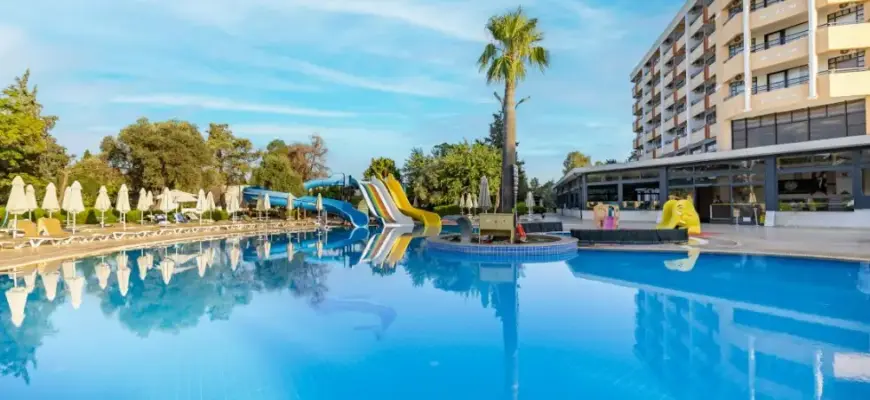 Как выбрать отель при покупке тура — курортный отель с бассейном, пальмами и зоной отдыха у воды.