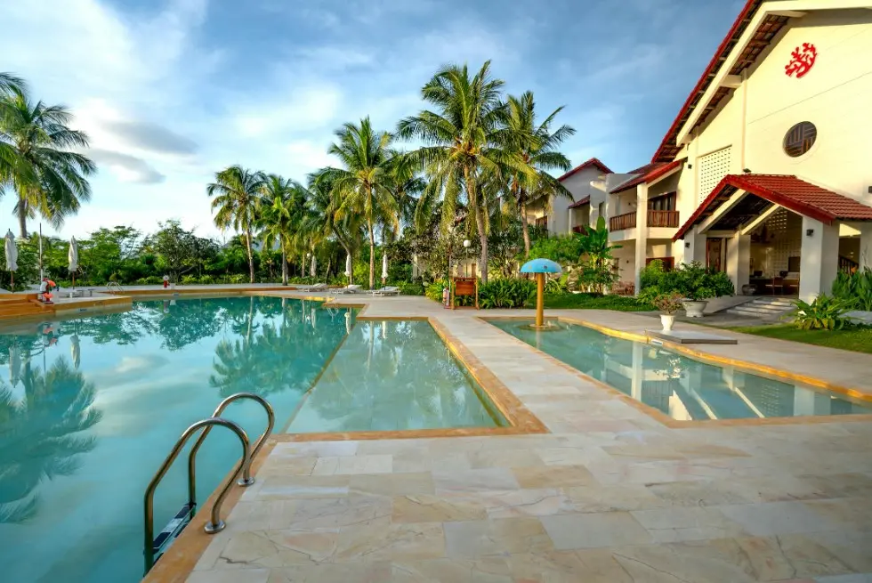 Как выбрать отель при покупке тура — курортный отель с бассейном, пальмами и тихой зоной отдыха на территории.