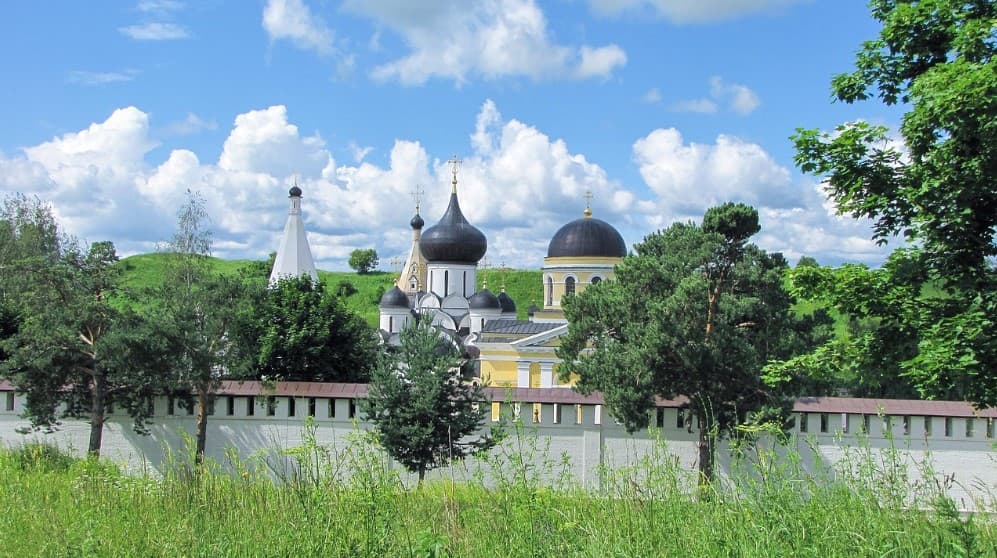 Когда лучше ехать на экскурсию по России: монастырь с куполами среди зелёных холмов в ясную погоду