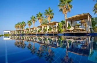 Квартиры и апартаменты или отель: что выбрать для тура — бассейн у курортного отеля с пальмами и зоной отдыха