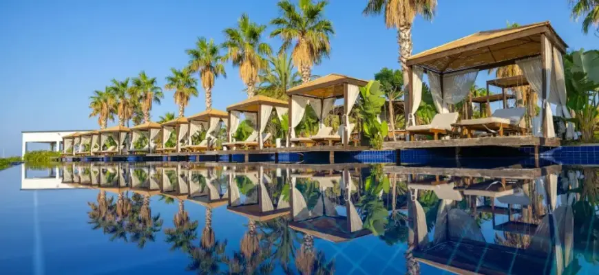 Квартиры и апартаменты или отель: что выбрать для тура — бассейн у курортного отеля с пальмами и зоной отдыха