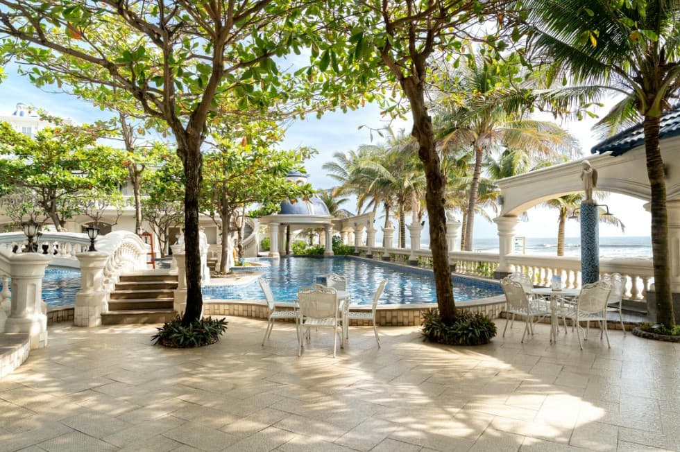 Квартиры и апартаменты или отель: что выбрать для тура — бассейн на территории курортного отеля у моря, пальмы и зона отдыха