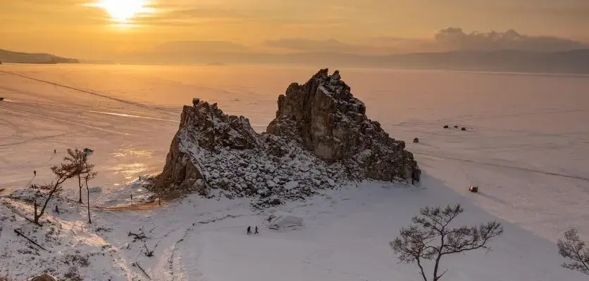 Необычные экскурсии по России: без музеев, больше впечатлений — зимний пейзаж с замёрзшим озером и скалами на закате