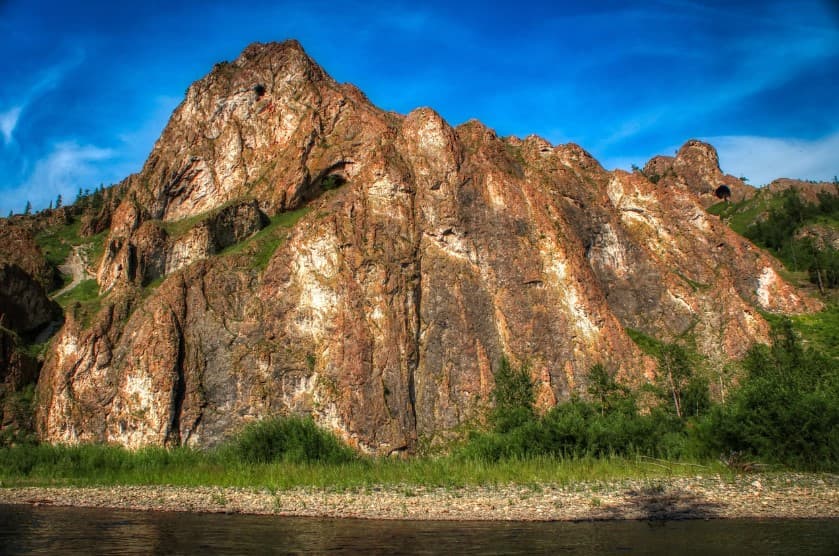 Незабываемые виды экскурсий на природе — скалистые горы и зелёная долина под ярким небом