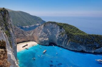 От чего зависит цена тура: топливный, курортный и регулярный сборы — бухта с голубой водой и скалистым берегом.