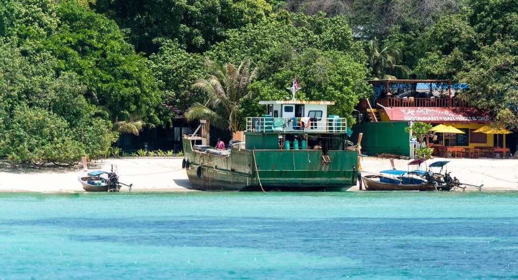 Питание на регулярных и чартерных рейсах — лодка у тропического берега и бирюзовое море