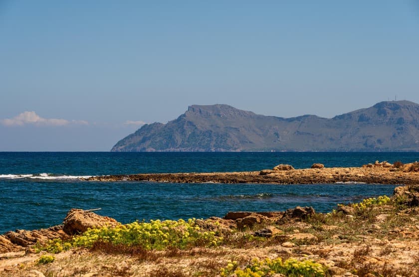 Тур без трансфера и страховки: стоит ли собирать пакет частями — каменистый морской берег и горы на горизонте