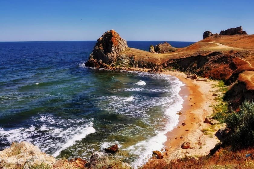 Экскурсии по России: морское побережье с песчаным пляжем, волнами и скалистыми мысами